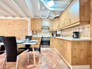Una cocina con gabinetes de madera y una mesa y sillas. en Daniela Garden, en Puerto de Santiago