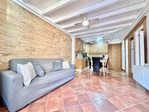 Una sala de estar con un sofá y una pared de ladrillos. en Daniela Garden, en Puerto de Santiago