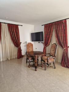 Zimmer mit einem Tisch, 2 Stühlen und einem TV in der Unterkunft Hotel Restaurante Setos in Motilla del Palancar