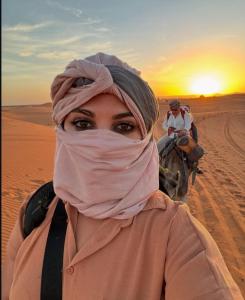 梅尔祖卡Desert Magic Camp的沙漠中戴着头巾的女人