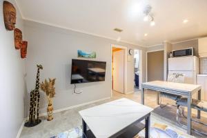 uma sala de estar com uma mesa e uma televisão na parede em Fresh Private Apartment Lower level- 2 beds em Brampton