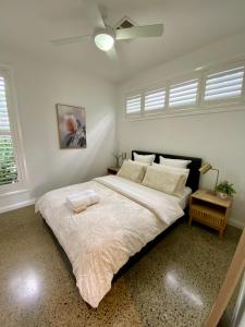 a bedroom with a large bed with a ceiling fan at East Woonona Sea Esta Studio in Woonona