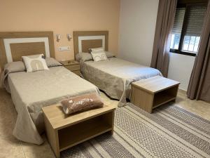 a room with two beds and two tables at Casa Rural Fuente Vieja in Malpartida de Plasencia +23 photos