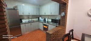 a small kitchen with white cabinets and a microwave at UF holiday Villa in Málaga