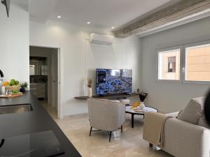 a living room with a couch and a tv on a wall at Navas 202 Elegant Suite in Granada