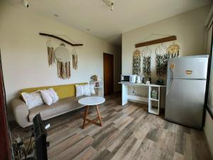 a living room with a couch and a table and a refrigerator at Malaica in Tafí del Valle