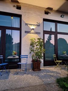 a building with two chairs and a potted plant on a patio at Al Ventisei - Azzurro in Treiso
