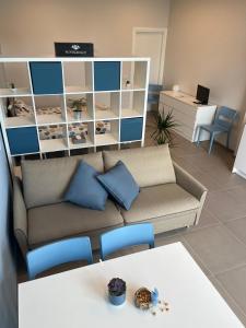 a living room with a couch and a table at Al Ventisei - Azzurro in Treiso