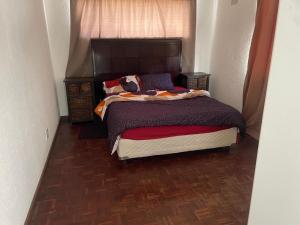 a bedroom with a bed with a wooden floor at House on Gill 2 in Cape Town