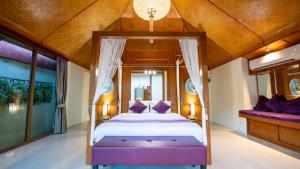 1 dormitorio con cama con dosel y almohadas moradas en Pattaya Bungalow I, Totally Private Pool, en Pattaya South 1 foto más