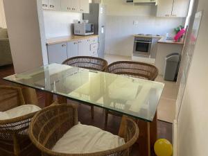 a kitchen with a glass table and some chairs at House on Gill 2 in Cape Town +2 photos