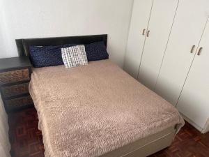 a small bed in a room with white cabinets at House on Gill 2 in Cape Town