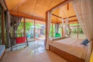 a bedroom with a canopy bed and a patio at Pattaya Bungalow II, Totally Private Pool in Pattaya South