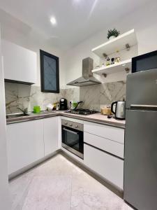 a white kitchen with white cabinets and appliances at Al Vicolo in Terracina
