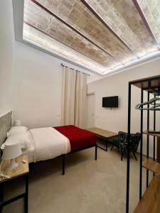 a bedroom with a bed and a table and a television at Al Vicolo in Terracina