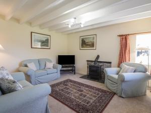 a living room with two chairs and a fireplace at Rarsaidh in Arnisdale