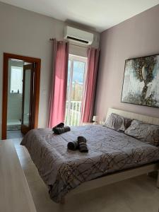 una camera da letto con un letto con due pantofole sopra di Sliema Shoreside Suite a Sliema