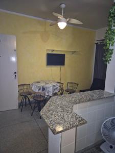 a living room with a table and chairs and a tv at Predio frente a praia ap 615 in Praia Grande