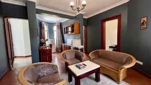 a living room with two chairs and a table at Nejobugg Apartment in Arusha