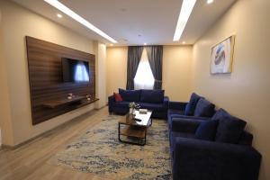 a living room with two blue couches and a tv at الريد فال للشقق المخدومة in Jeddah