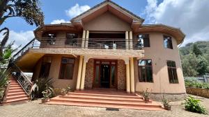 a large house with a balcony on top of it at Nejobugg Apartment in Arusha