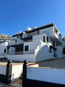 a white building with a fence in front of it at Casa da Rocha-Praia da Rocha & Spa in Portimão