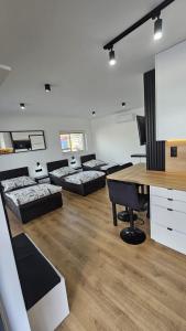 伊诺弗罗茨瓦夫Anpol的客房设有四张床、一张桌子和一张书桌。