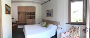 a bedroom with a white bed and a kitchen at La Casa di Andrea Relais in Monterosso al Mare