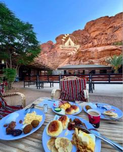 a table with plates of breakfast food on it at RUM WORLD BUBBLE lUXURY CAMP in Wadi Rum