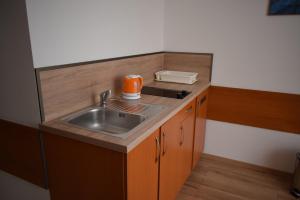 a small kitchen with a sink and an orange appliance at Penzión Centrum in Oravský Biely Potok +63 photos