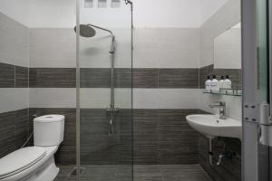 a bathroom with a shower and a toilet and a sink at Phê Hotel in Da Nang