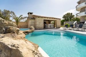 a swimming pool in front of a house at Villa Lea ZadarVillas in Zaton