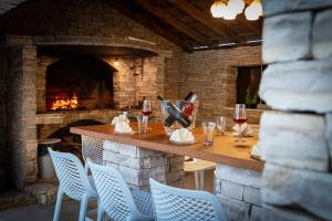 a bar with a table and chairs and a fireplace at Villa Lea ZadarVillas in Zaton