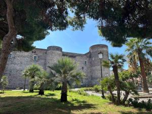 un grande castello con palme di fronte di ChiaraLuce House a Catania