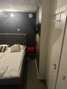 a small bedroom with a bed and a small door at Hotell Skeppsbron in Stockholm
