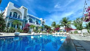 a swimming pool in front of a house at Santorini Villa Cam Ranh in Cam Ranh