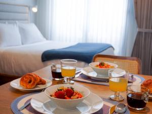 a table with two plates of food and two glasses of orange juice at Art Homes 85 in Bogotá