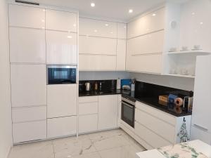 a white kitchen with white cabinets and appliances at Nationalpark Apartments in Apetlon