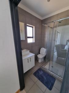 a bathroom with a shower and a toilet and a sink at Kanyamazane Guesthouse 1214 in eNyamazaneni