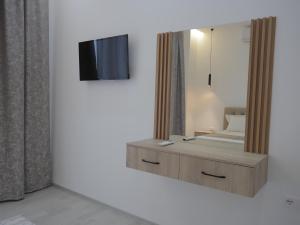 a bedroom with a mirror and a bed and a tv at Shatri Hotel in Vranisht +37 photos