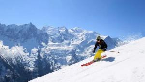 un hombre está esquiando por una montaña cubierta de nieve en Apartment Midi Loft - A Central Chamonix Mountain Haven, en Chamonix-Mont-Blanc