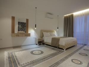 a bedroom with a bed and a mirror and a rug at Shatri Hotel in Vranisht