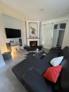 a living room with a black couch and a fireplace at Ferienwohnung im alten Forstamt in Erndtebrück