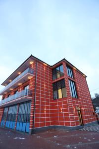 a red brick building with windows on a street at Shatri Hotel in Vranisht