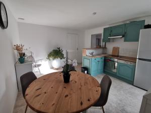 een keuken met een houten tafel met stoelen erin bij Épi Cottage in Coulgens +7 foto's