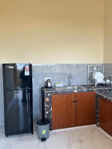a kitchen with a black refrigerator and a sink at Villa Lestari in Ubud