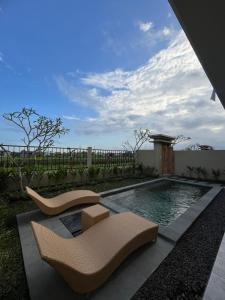 a patio with two chairs and a swimming pool at Villa Lestari in Ubud
