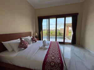 a bedroom with a large bed and a large window at Villa Lestari in Ubud