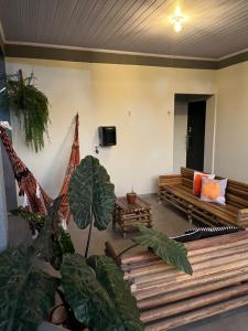 a living room with wooden benches and plants at Suítes Preguiça in Sao Jorge