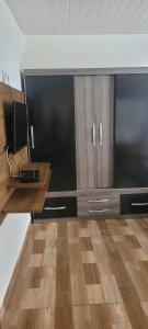 a kitchen with wooden cabinets and a wooden floor at Casa de 2 quartos no Circuito das Aguas - Churrasqueira, fogão e forno a lenha in Lindóia